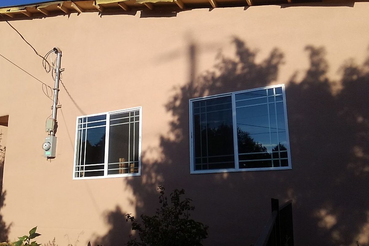 Two-story home in Tijeras with a finished stucco wall over spray foam